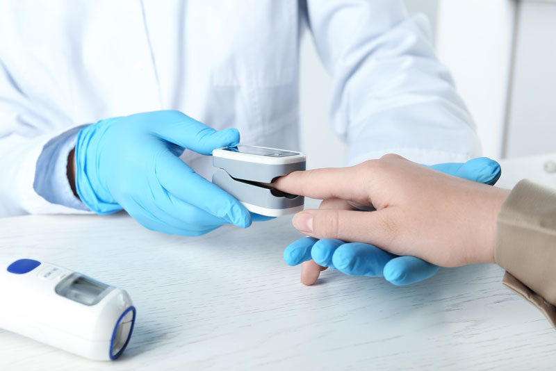 a dentist using a pulse oximeter on an implant patient.