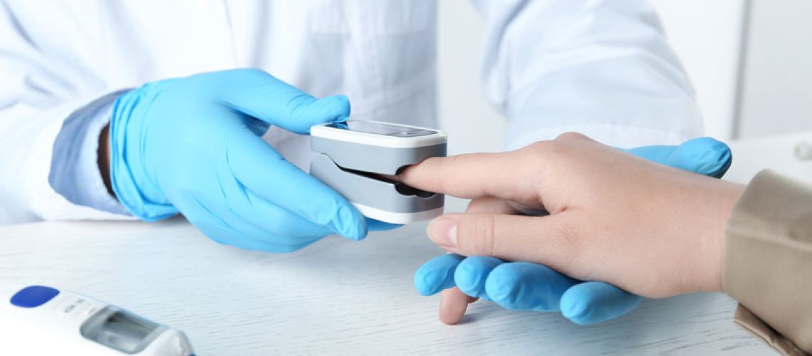 a dentist using a pulse oximeter on an implant patient.